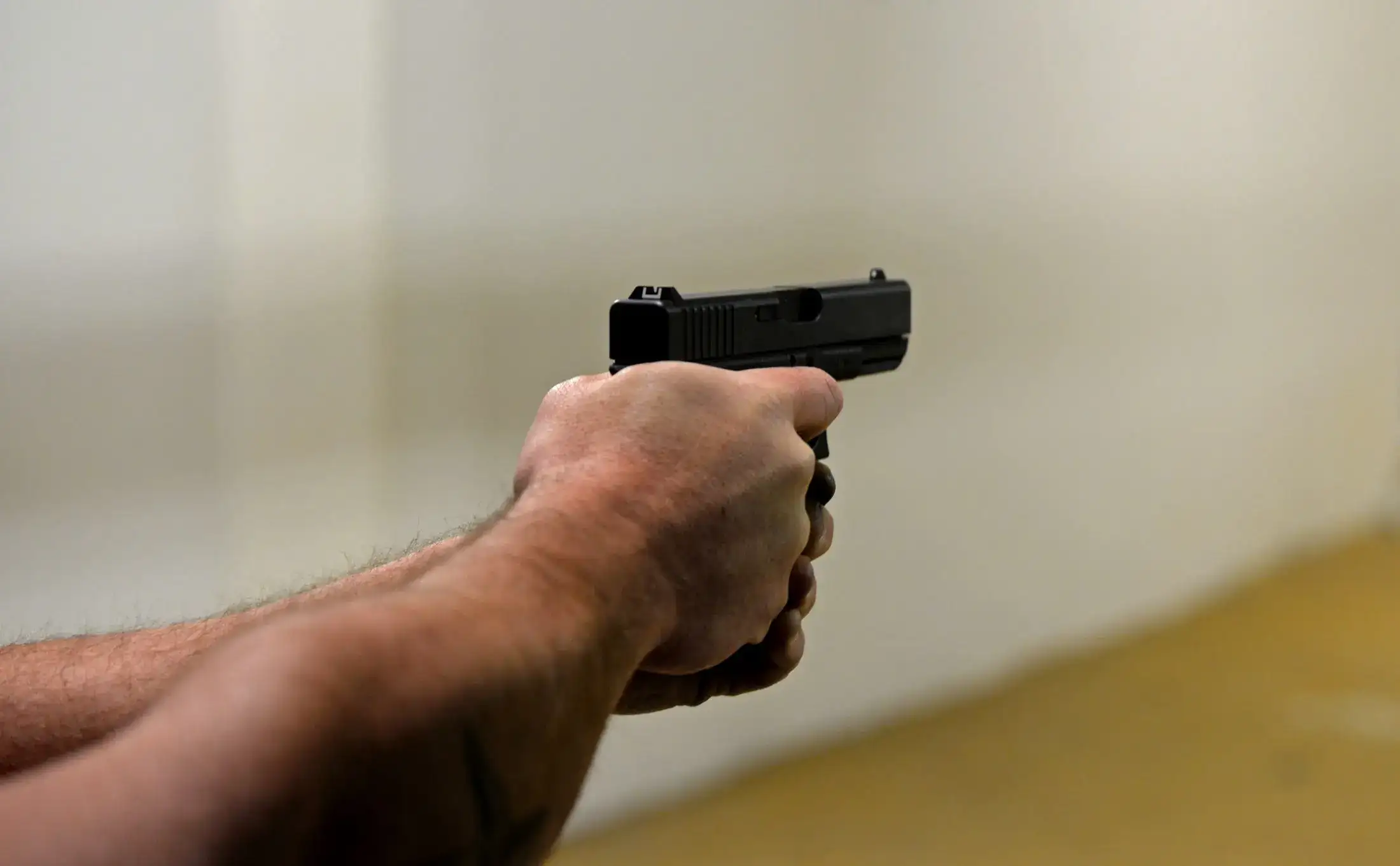 Firing a pistol at the range.