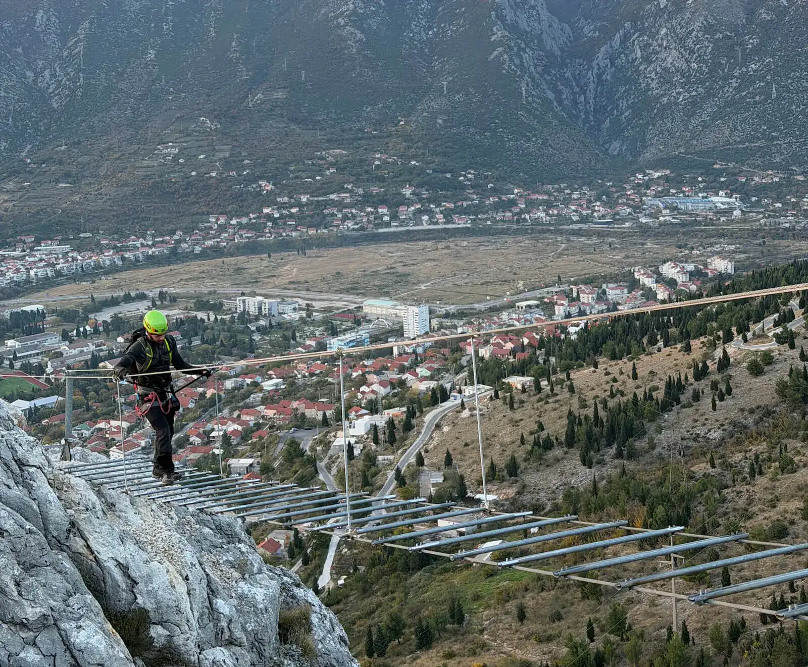 Crossing the bridge above Mostar, with the city and the mountains behind.