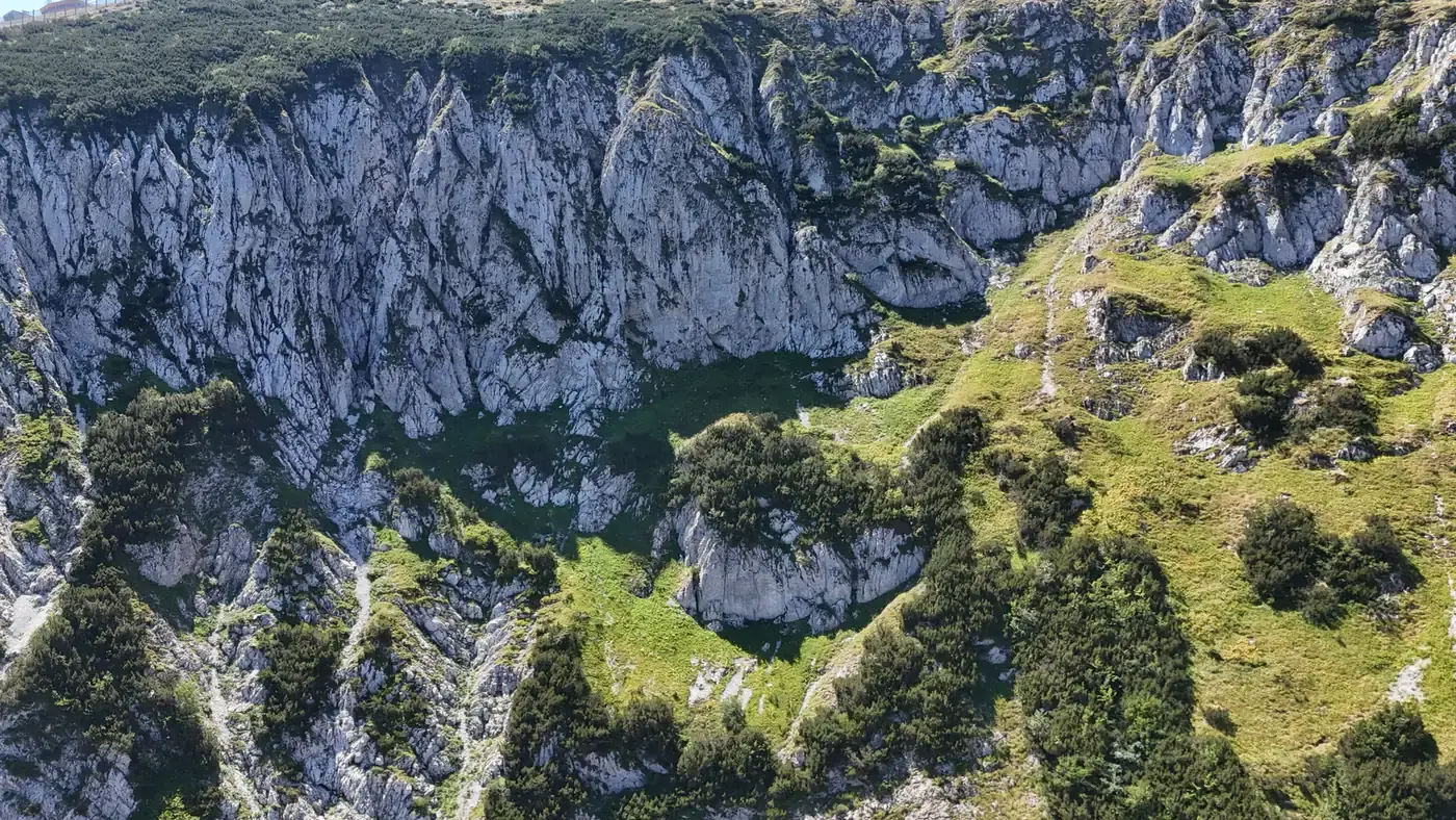 Drone view into the Kotlovi bowl on Bjelašnica, with limestone cliffs around a green hollow