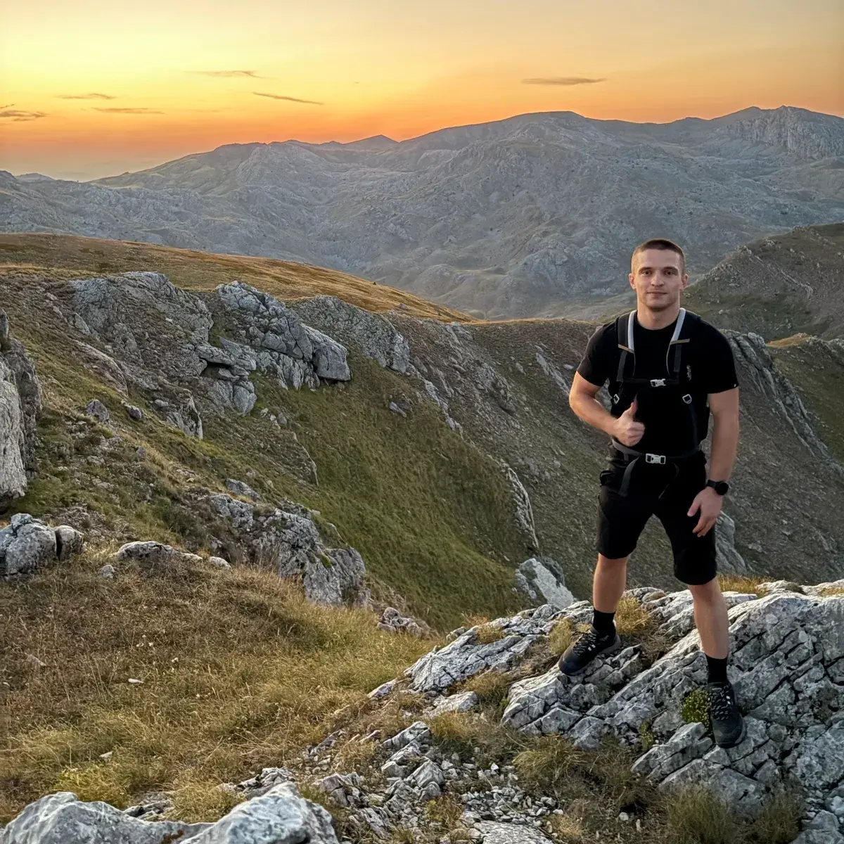 Rahmo, BOA outdoor guide, on a rocky mountain ridge at sunset
